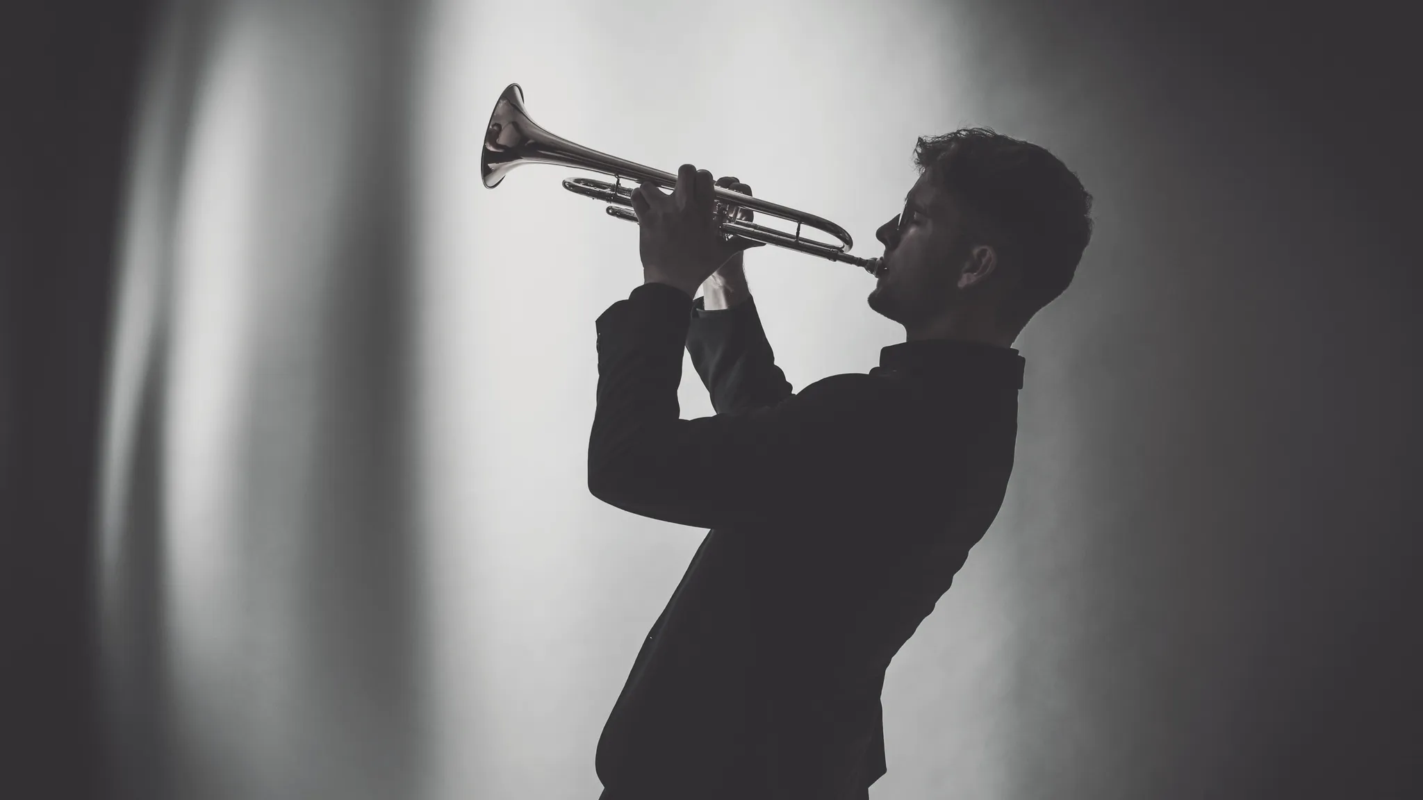 Valentin Annerbo auf der Bühne, Gegenlicht-Silhouette mit Trompete.