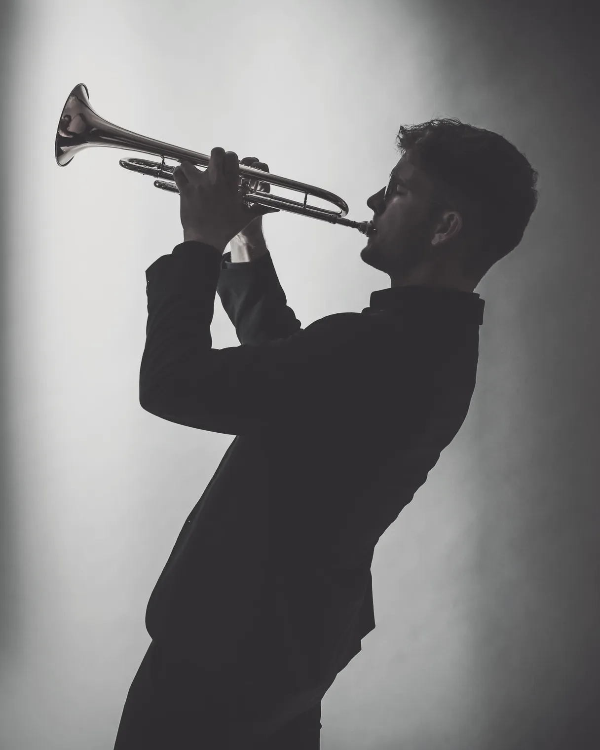 Valentin Annerbo performing on stage, backlit silhouette with trumpet.
